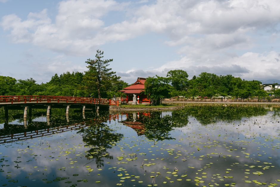 Dazaifu Tenmangu main hall across the pond and arched stone bridges
