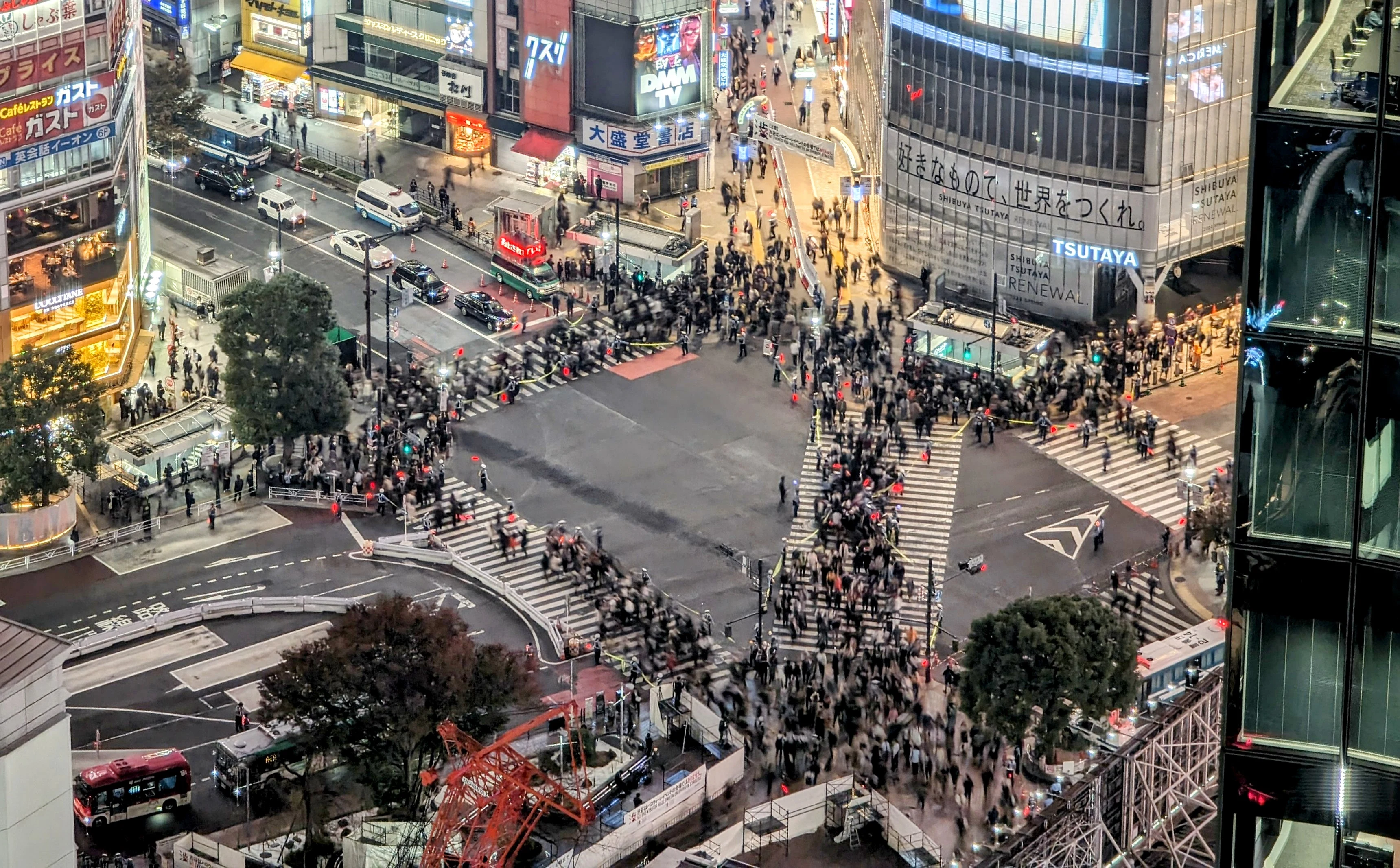 Shibuya Scramble Crossing at dusk with neon billboards