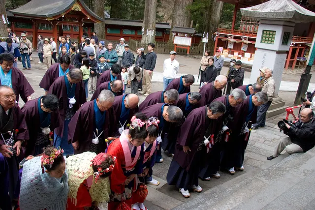Participants in festival dress bowing at Futarasan Shrine during the Nikko Yayoi Matsuri