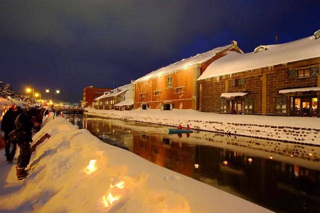 Candles lining the snowy Otaru canal at dusk